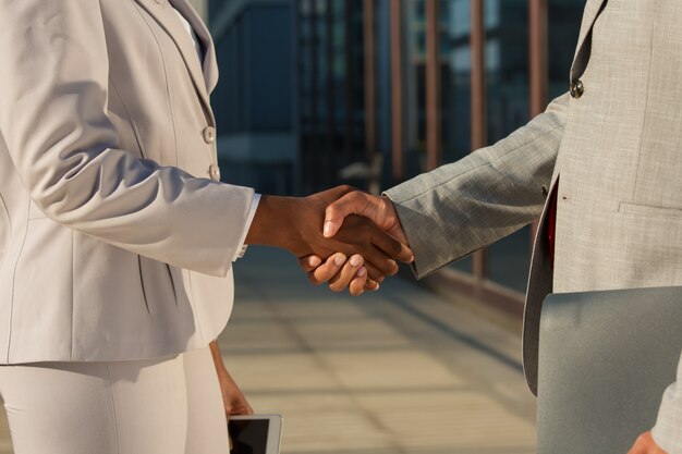 Zwarte zakenvrouw handen schudden met mannelijke partner