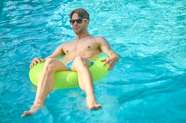 Zwembad. Jonge man met een gele buis in een zwembad